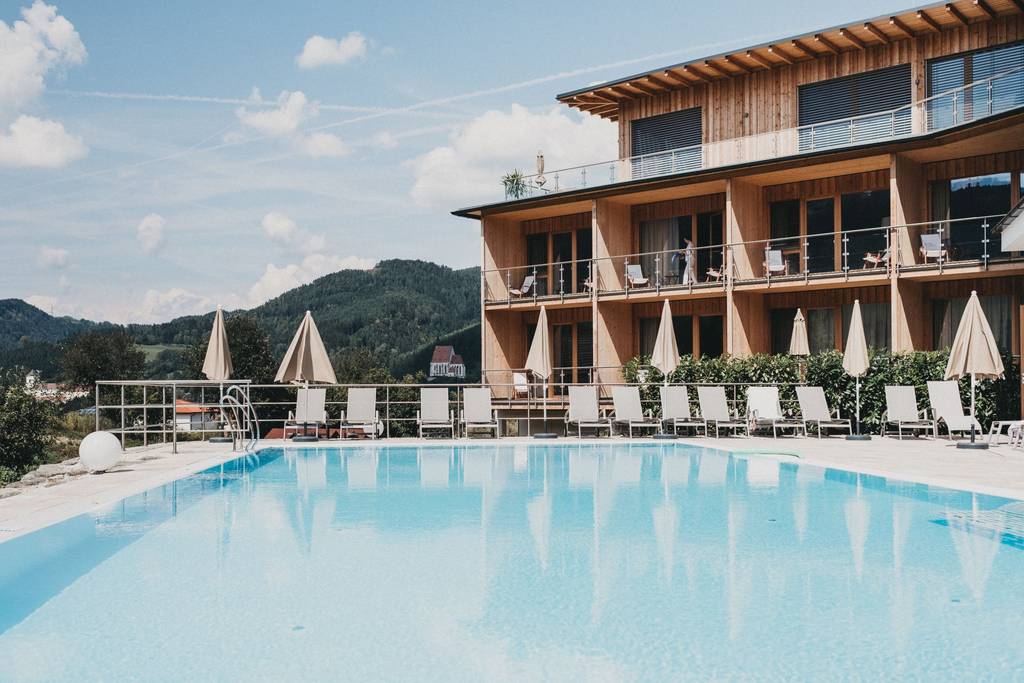 Beheizter Pool des Molzbachhof mit Blick auf das Holzhotel