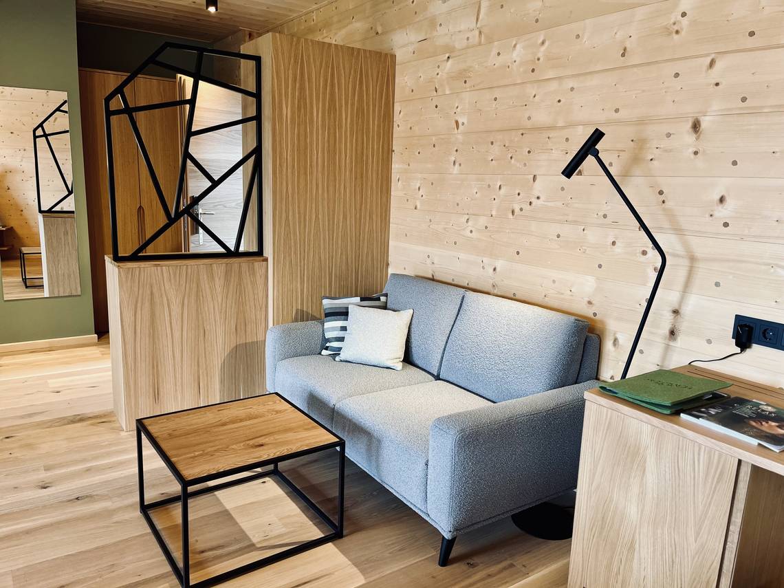 Couch mit Tisch im Zimmer Weitblick im Naturhotel Molzbachhof.