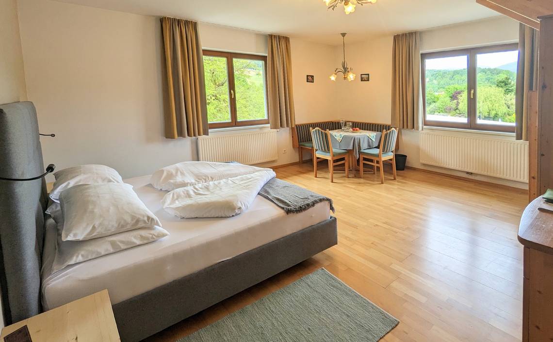 Turmzimmer mit Doppelbett und Sitzecke im Naturhotel Molzbachhof.