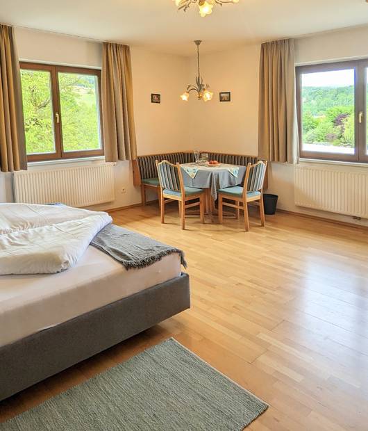 Turmzimmer mit Doppelbett und Sitzecke im Naturhotel Molzbachhof.
